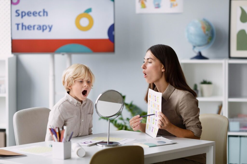 woman doing speech therapy with a child in her clinic