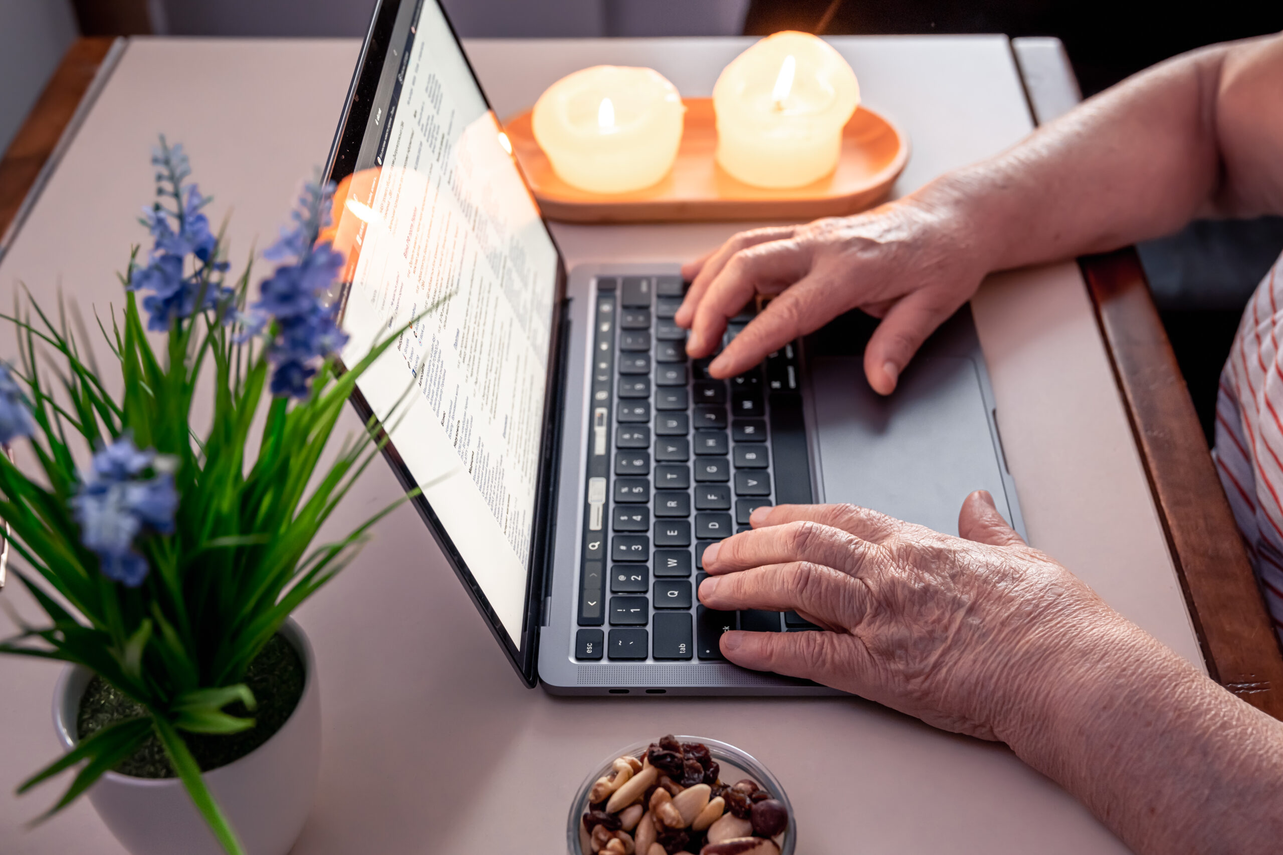 Old woman uses laptop, hands close up, technology and old people concept.