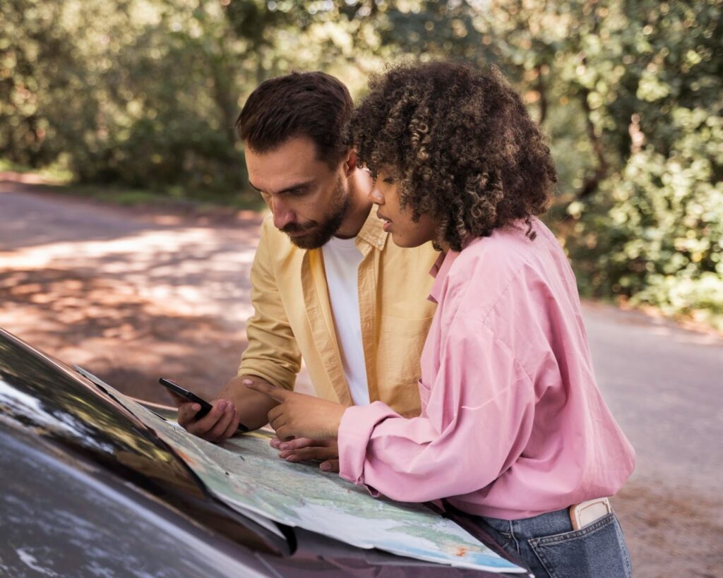 Side view of the couple outdoors consulting the map